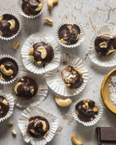 Dark chocolate cashew clusters topped with flaky sea salt in mini muffin liners