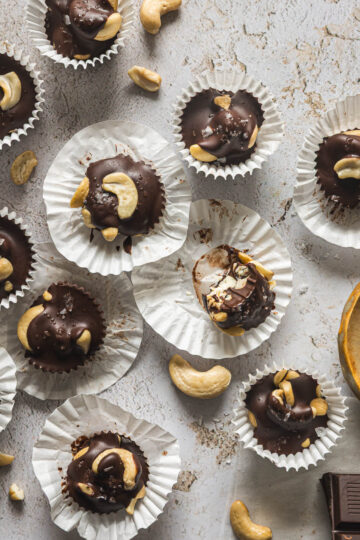 Dark chocolate cashew clusters topped with flaky sea salt in mini muffin liners