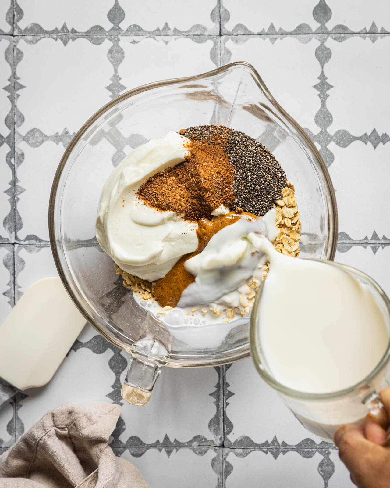 Adding milk to oats, Greek yogurt, chia seeds and almond butter