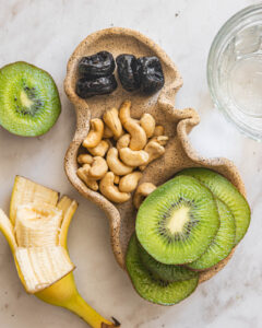 Kiwi banana cashew snack plate with prunes