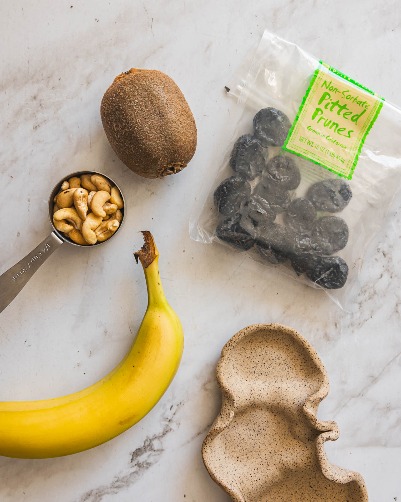 Kiwi, banana, prunes and cashews for a simple snack plate