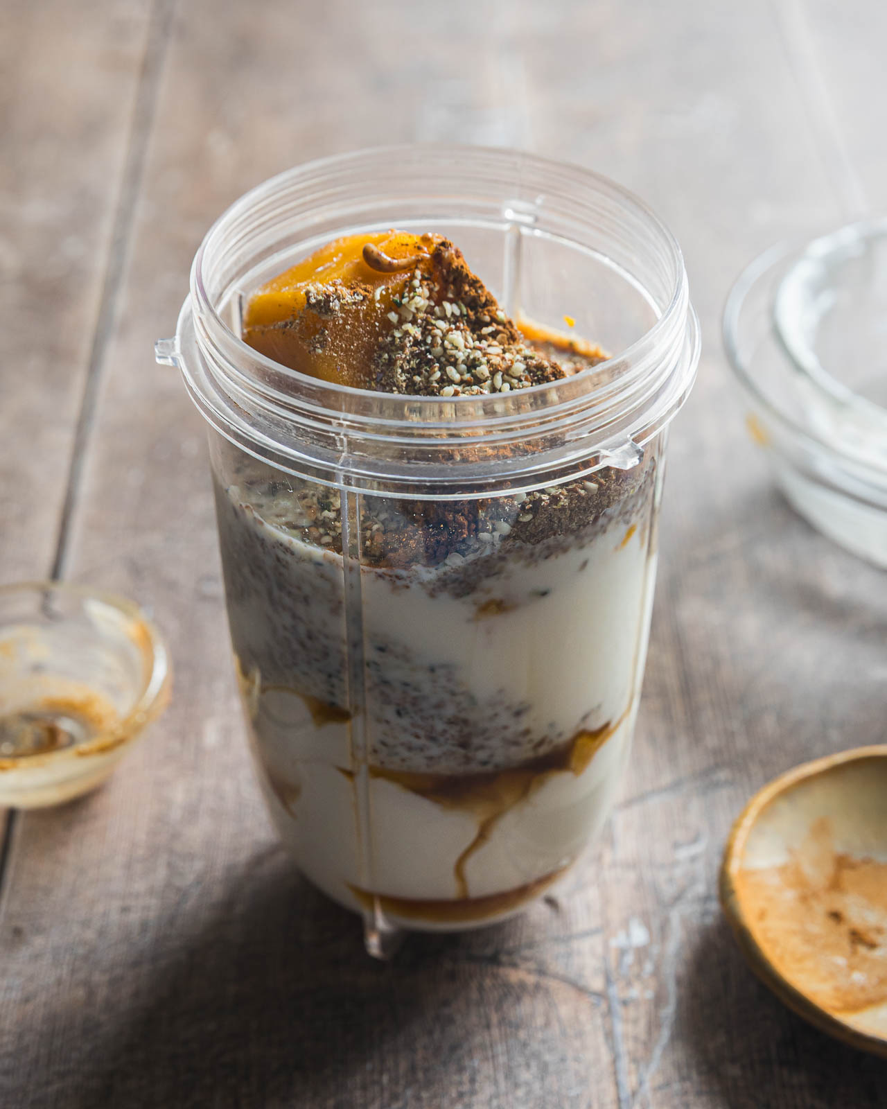 Frozen pumpkin, Greek yogurt, flaxseed, hemp hearts and other smoothie ingredients in a blender cup