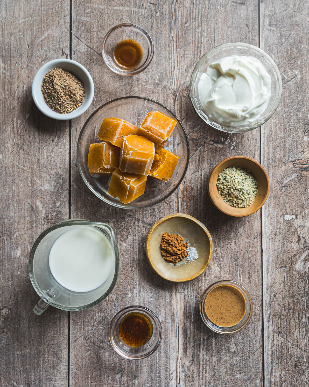 Ingredients for a protein pumpkin smoothie arranged on a rustic wood table