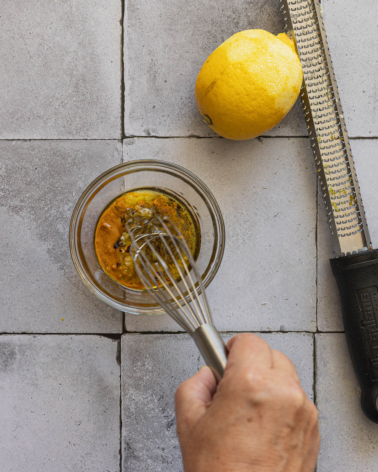 Olive oil, garlic, lemon zest and turmeric being whisked together for roasted cauliflower
