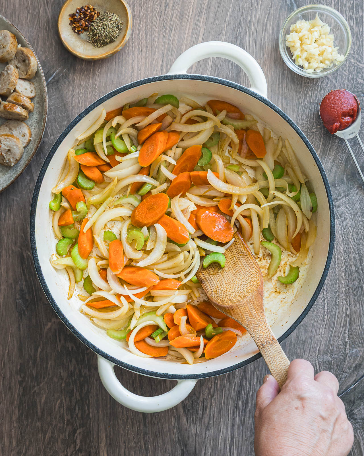 Sliced onions, carrots and celery sautéing in a braiser