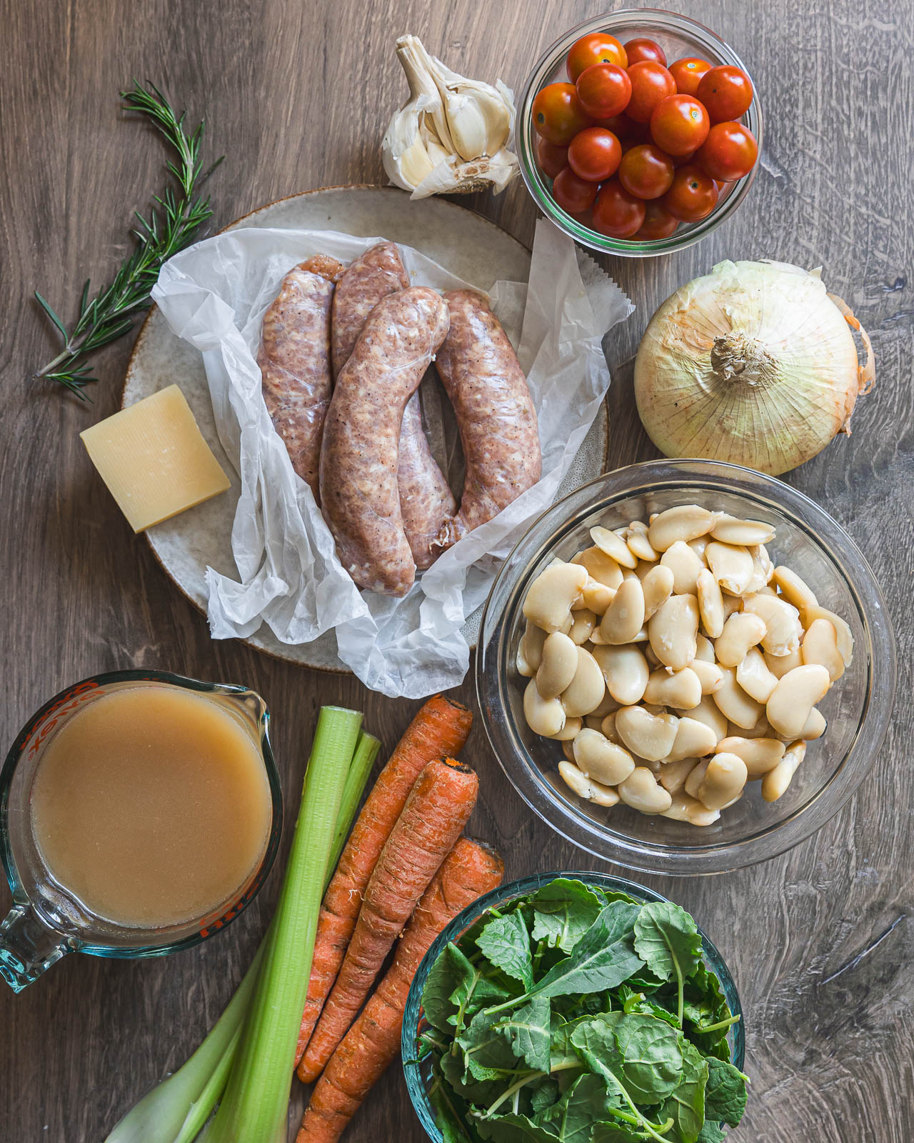 Ingredients for butter bean stew with Italian chicken sausage arranged on a table