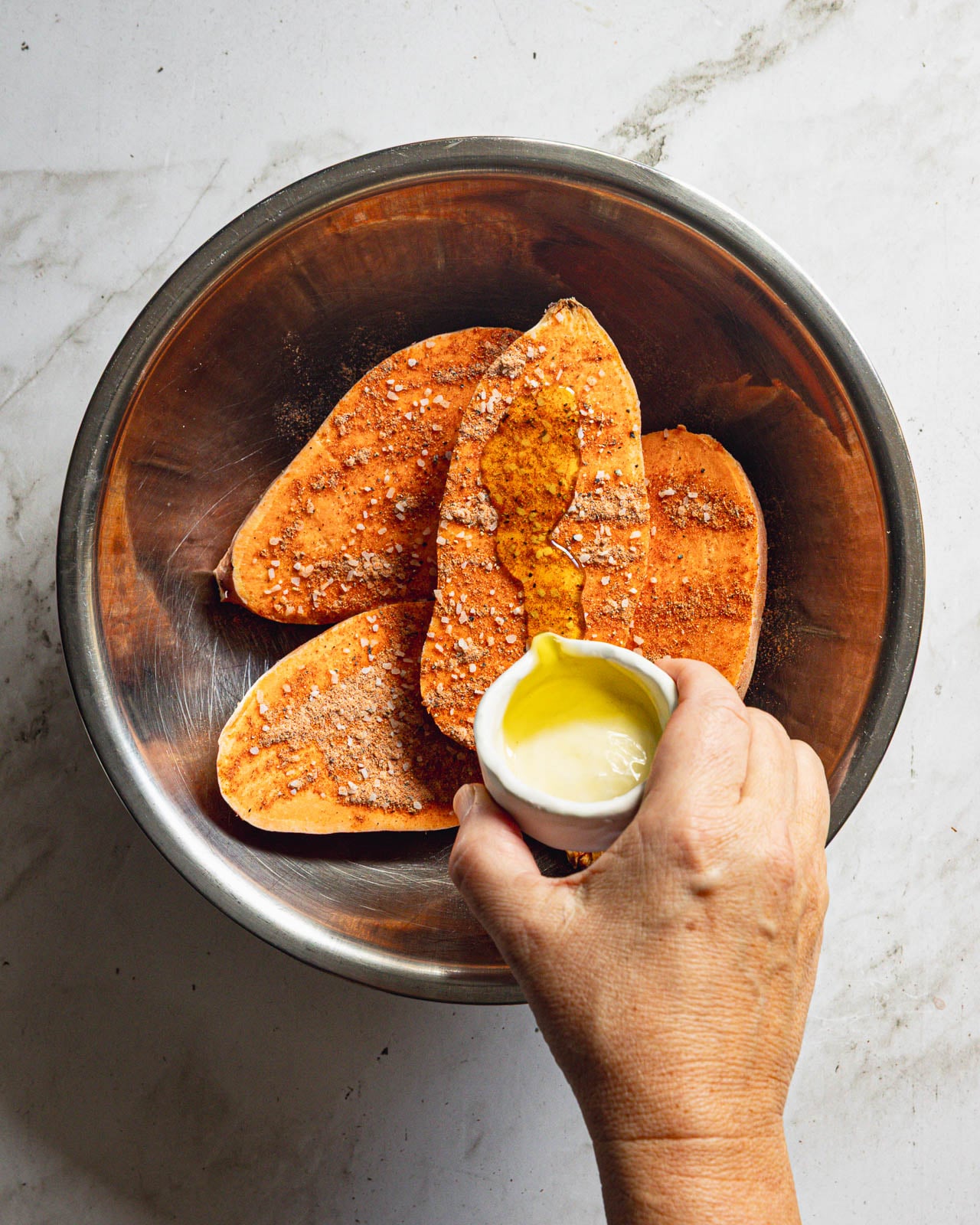 Sweet potato halves seasoned with smoked paprika and garlic powder and drizzled with olive oil