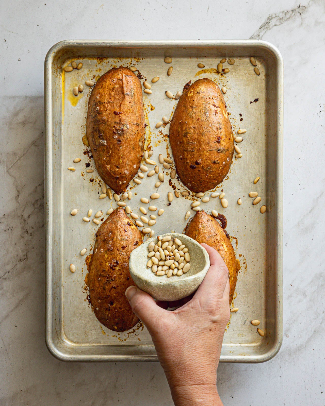 Pine nuts added to the sheet pan during the last few minutes of roasting sweet potatoes