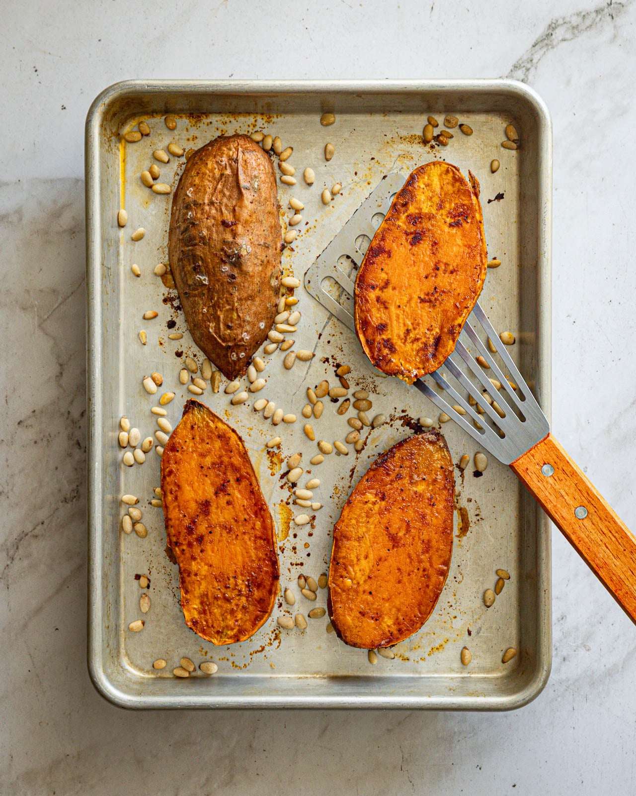 Roasted sweet potato halves flipped over to show their browned caramelized surfaces