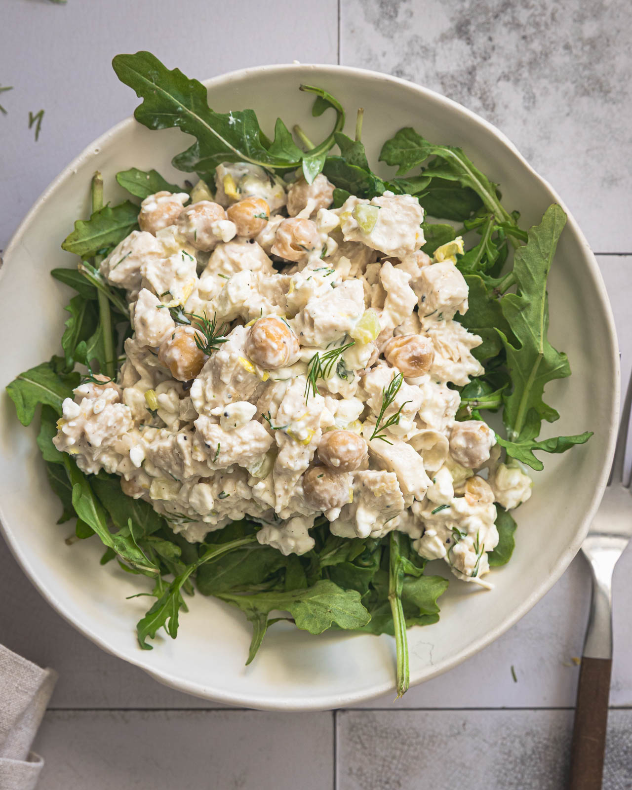 Chicken and chickpea salad served over a bed of arugula