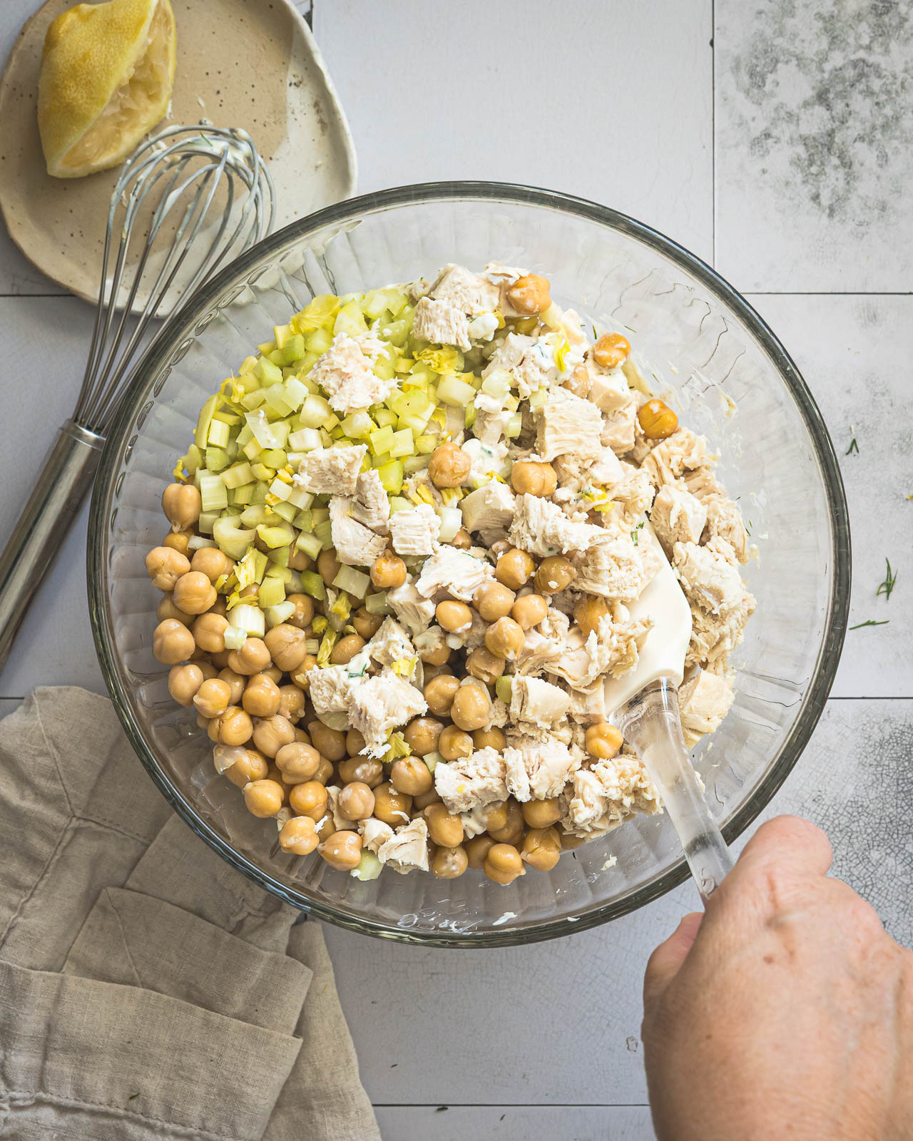 Folding chicken, chickpeas and celery into creamy dressing