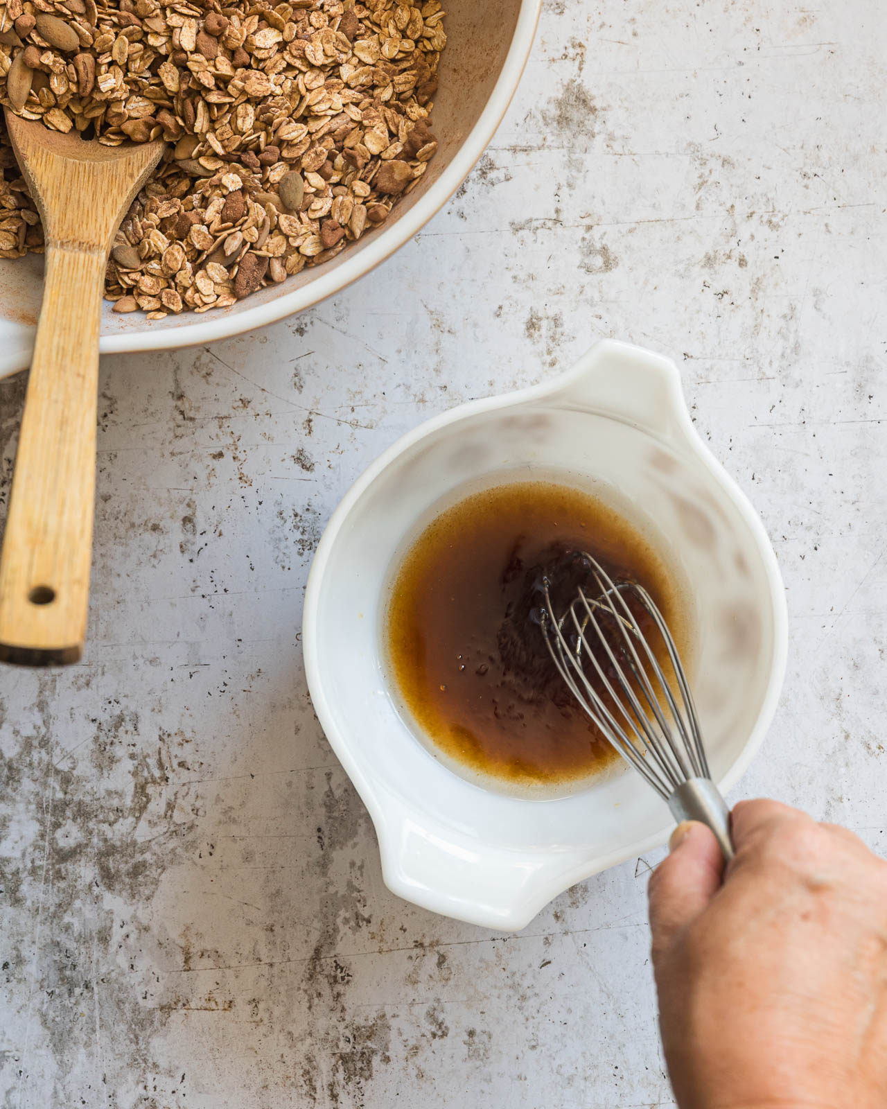 Maple syrup, melted coconut oil and vanilla being whisked together for chocolate granola