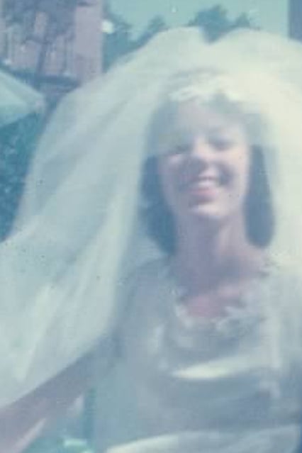 Vintage wedding photograph of my mom smiling in her wedding dress and veil.